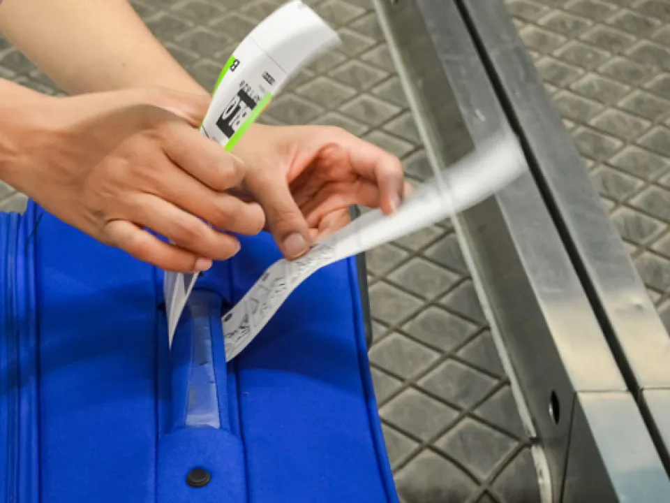 Person adding security label to luggage
